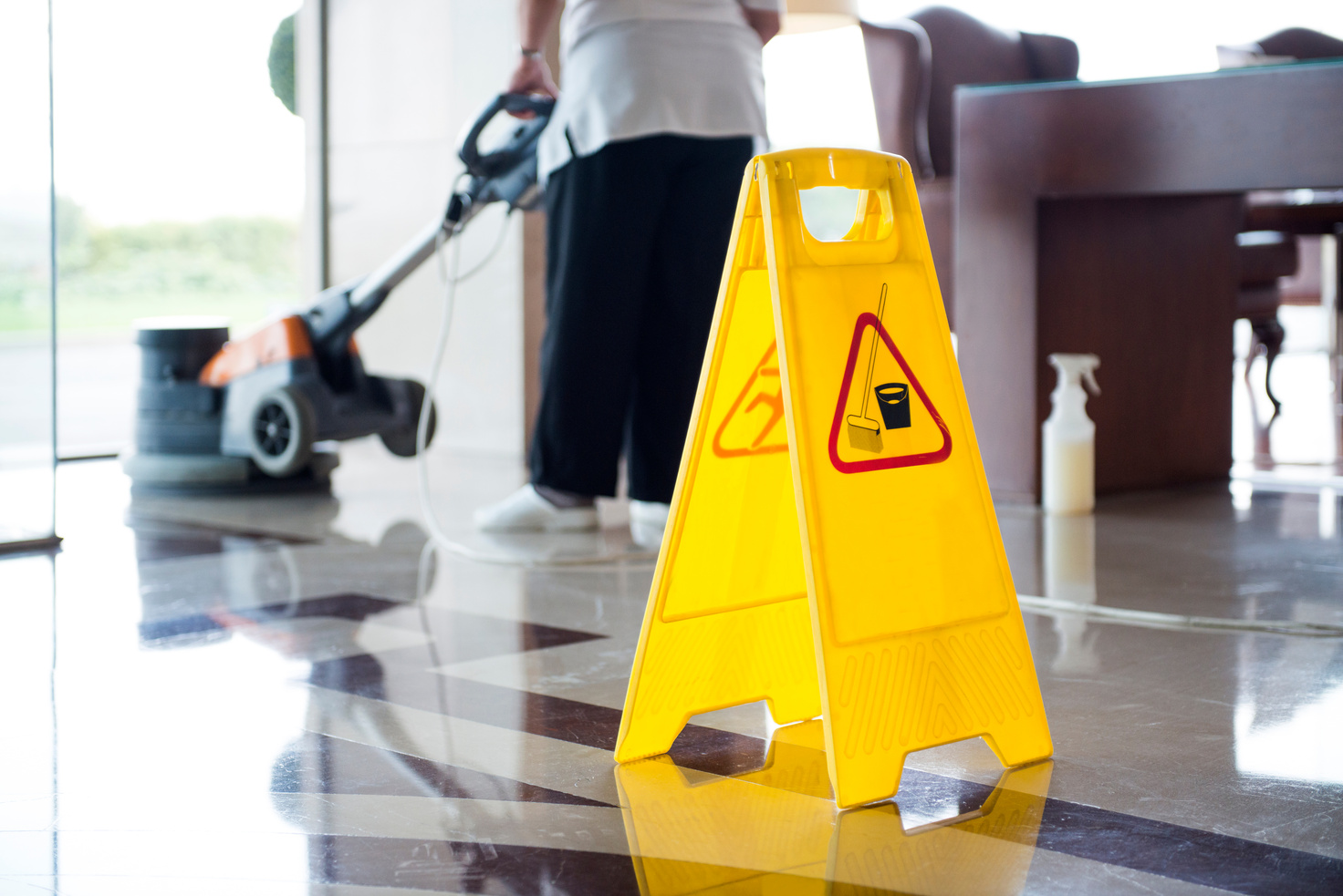 Personnel cleaning office space area with vacuum